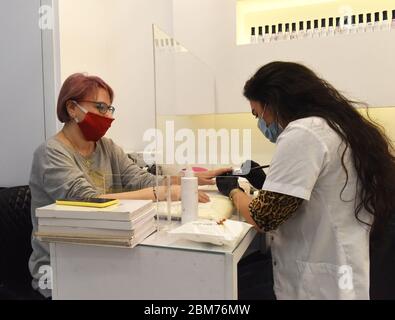 Atarot, Israel. Mai 2020. Eine Frau trägt eine Maske, als Vorsichtsmaßnahme gegen COVID-19, während sie am Donnerstag, den 7. Mai 2020, ihre Nägel in der Rami Levy Atarot Mall nördlich von Jerusalem manikieren lässt. Israel eröffnete heute Einkaufszentren und Märkte im Freien, nachdem sie mehr als 40 Tage wegen der Beschränkungen der Coronavirus-Pandemie geschlossen wurden. Die Atarot Mall ist die erste israelisch-palästinensische Mall. Foto von Debbie Hill/UPI Quelle: UPI/Alamy Live News Stockfoto