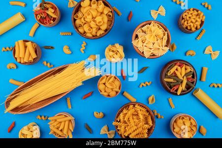 Verschiedene Nudelsorten auf blauem Hintergrund, Draufsicht, flaches Lay Stockfoto