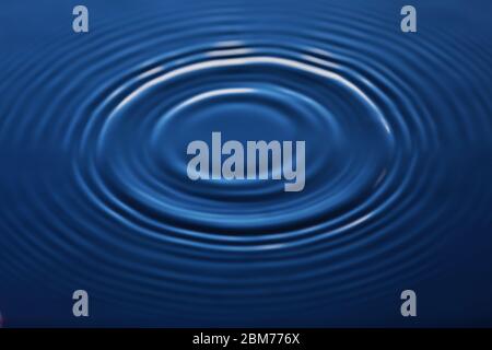 Ein Tropfen Wasser fällt ins Wasser, was einen perfekten Tropfen macht. Stockfoto