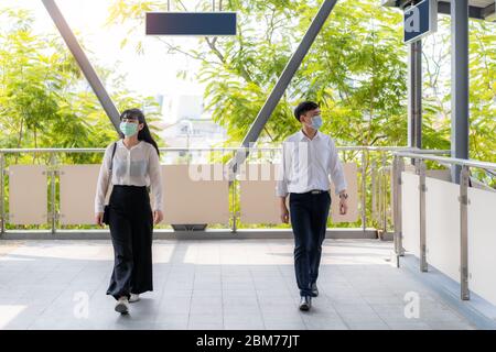 Zwei asiatische Mann und Frau halten Abstand von zwei Metern oder 6 Fuß zwischen jeder Person zu Fuß oder Skywalk für soziale Entfernung für Infektion r Stockfoto