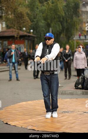 Junger Mann, Straßentänzer, auf dem Bürgersteig tanzend, Menschen beobachtend. 21.Mai 2012. Kiew, Ukraine Stockfoto