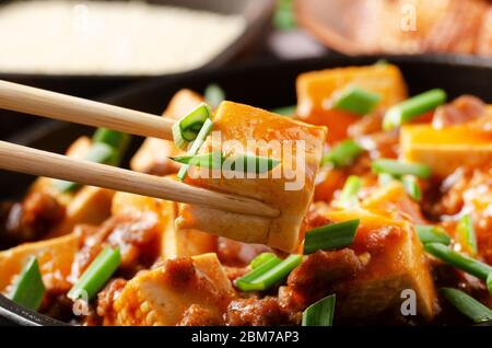 Mapo Tofu Gericht Sojabohnenbrocken Stück in Essstäbchen gehalten Stockfoto