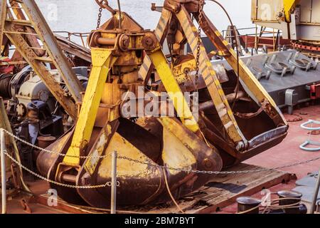 Rostige Baggerkübel auf dem Deck eines Flussschiffes Stockfoto