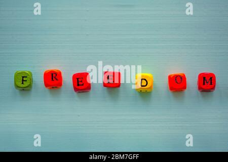 Wortfreiheit mit Würfel auf buntem Hintergrund, konzeptuell. Stockfoto