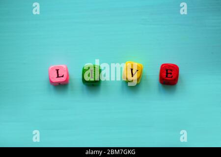 Wort leben mit Würfel auf bunten Hintergrund, konzeptionell. Stockfoto