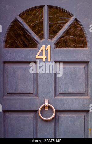 Die Hausnummer 41 auf der hölzernen Vordertür unter dem Halbkreis des Glases Stockfoto