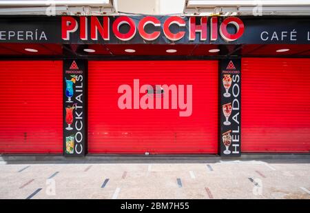 Benidorm, Alicante Spanien, 4.5.2020, Corona Krise: Ein Schild "Se Traspasa" (zur Übernahme erhältlich) Hinweis auf der roten Rollladen eines Eiscafés. Die Zwangsschließungen aufgrund der Pandemie haben viele Geschäftsleute in wirtschaftliche Schwierigkeiten geraten lassen und einige von ihnen wollen oder können ihre Geschäfte nicht mehr führen Stockfoto