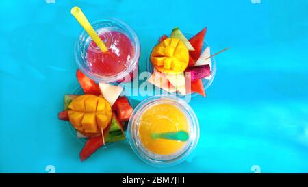 Zitrusfrüchte und Scheiben exotischer Früchte auf blauem Hintergrund - Sommer Stockfoto