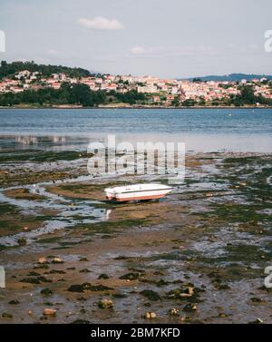 Altes Holzboot bei Ebbe mit Moos in Combarro, Nordspanien Stockfoto