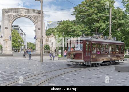 CHRISTCHURCH, NEUSEELAND - Dezember 03 2019: Stadtbild mit Straßenbahn-Biegung am monumentalen Remebrance Bridge-Bogen, aufgenommen in hellem Frühlingslicht auf dece Stockfoto