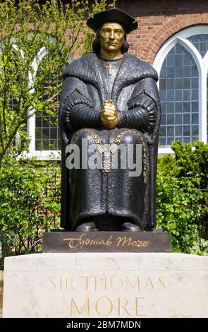 Sitzende moderne Statue von Thomas More, 1968, von der Bildhauerin Leslie Cubitt Bevis. Bemalte Bronzeskulptur Vor der Chelsea Old Church, Chelsea Embankment, London. GROSSBRITANNIEN. (118) Stockfoto