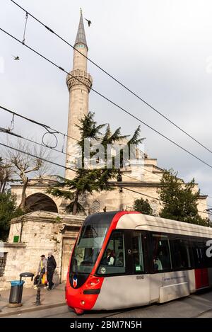 21. Februar 2018: Straßenbahn, die in der Nähe einer Moschee im Stadtteil Sultanhamet vorbeifährt. Istanbul, Türkei Stockfoto