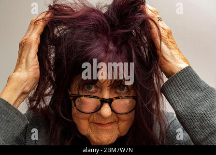 Ältere Frau kann nicht einen Haarschnitt zu der Coronavirus Sperrung bekommen Stockfoto