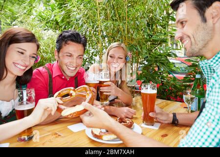 Biergruppe lacht im Biergarten in Bayern beim Oktoberfest Stockfoto