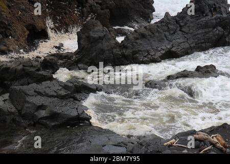 Palikea Bach, der durch vulkanisches Gestein fließt und in den Pazifik am Oheo Gulch in Hana, Maui, Hawaii, USA fließt Stockfoto