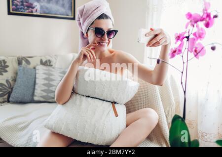 Pillow Challenge zu Hause während der Quarantäneisolation des Coronavirus pandemic. Junge Frau, die Selfie trägt Kissen Stockfoto