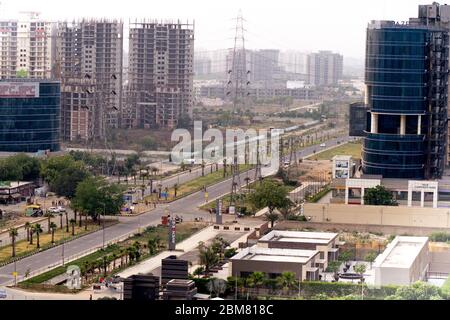 Aufnahme, die die leeren Straßen und Kreuzungen zeigt, die sich in der modernen Stadt gurgaon zu Wolkenkratzern mit Resedenzen, Häusern, Büros und mehr bewegen Stockfoto