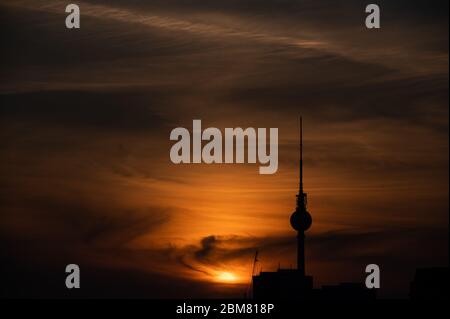 Berlin, Deutschland. Mai 2020. Die Sonne geht hinter dem Fernsehturm unter und der Himmel wird orange. Kredit: Christophe Gateau/dpa/Alamy Live News Stockfoto