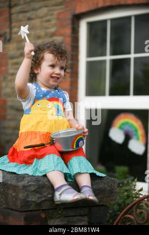 Swansea, Wales, Großbritannien. Mai 2020. Die zweijährige Lillian Joy zeigt ihre Unterstützung für den NHS und die Schlüsselarbeiter außerhalb ihres Hauses in Swansea, Wales, indem sie an dem wöchentlichen Clap for our carers während der Sperrung der Coronavirus-Pandemie in Großbritannien teilnimmt. Quelle : Robert Melen/Alamy Live News Stockfoto