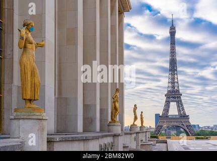 Paris, Frankreich - 05 06 2020: Goldene Statue einer Frau, die während der Haft gegen Coronavirus und den eiffelturm eine Operationsmaske trägt Stockfoto