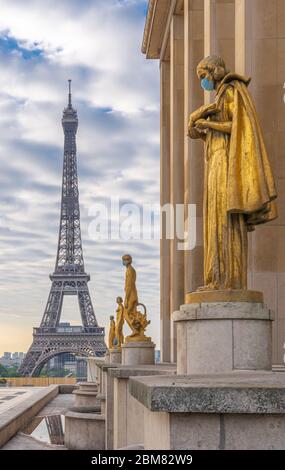 Paris, Frankreich - 05 06 2020: Goldene Statue einer Frau, die während der Haft gegen Coronavirus und den eiffelturm eine Operationsmaske trägt Stockfoto