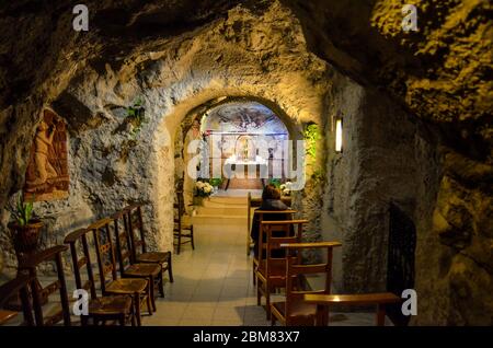 Budapest, Ungarn - 6. November 2019: Innenraum der Gellert-Höhlenkirche, Sziklatemplom. Felsenkirche in der ungarischen Hauptstadt. Person, die auf dem Stuhl vor dem Altar sitzt. Stockfoto