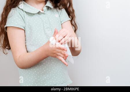 Das Kind wischt ihre Hände nass antibakterielle Tuch. Die Bedeutung der persönlichen Hygiene. Der Kampf gegen das Virus. Stockfoto