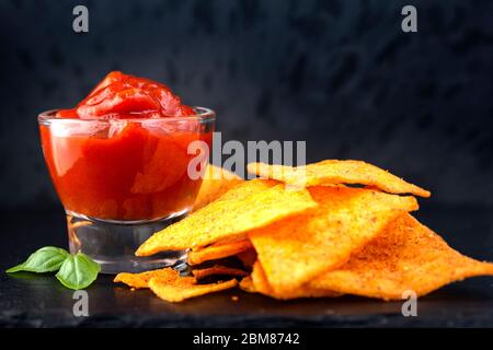 Tortilla Chips und eine Glasschüssel mit Salsa-Sauce gefüllt Stockfoto