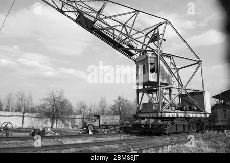 Rostiger Kran auf blauem Himmel Hintergrund, Shooting im Frühjahr an einem sonnigen Tag, schwarz-weiß-Foto Stockfoto