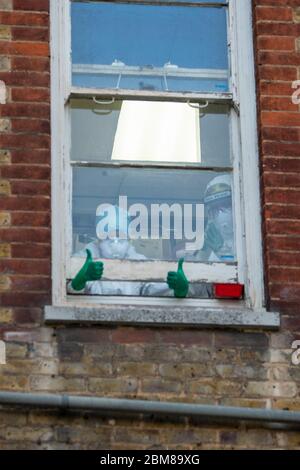 Southend-on-Sea, Großbritannien. Mai 2020. Das Intensivpersonal des Southend University Hospital gibt während des landesweiten Clap-for-Care-Tributs während der COVID-19-Pandemie einen Daumen nach oben aus einem Fenster. Penelope Barritt/Alamy Live News Stockfoto