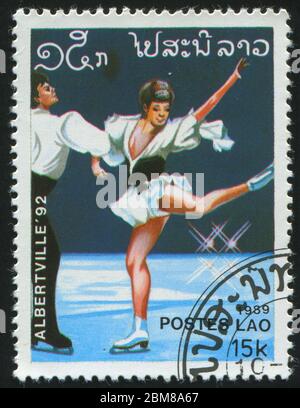 LAOS - UM 1989: Briefmarke gedruckt von Laos, zeigt professionelle Eiskunstläufer, um 1989. Stockfoto