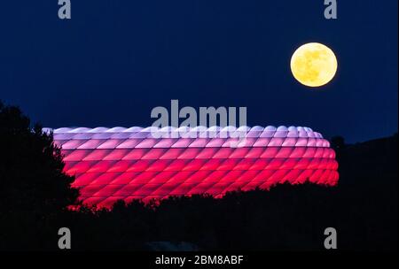 München, Deutschland. Mai 2020. Der Vollmond erhebt sich hinter der beleuchteten Allianz Arena. Quelle: Peter Kneffel/dpa/Alamy Live News Stockfoto