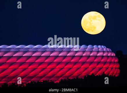 München, Deutschland. Mai 2020. Der Vollmond erhebt sich hinter der beleuchteten Allianz Arena. Quelle: Peter Kneffel/dpa/Alamy Live News Stockfoto