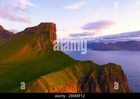 Kallur Leuchtturm auf grünen Hügeln der Insel Kalsoy, Färöer, Dänemark. Landschaftsfotografie Stockfoto