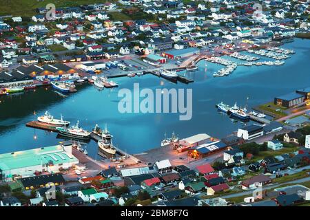 Atemberaubende Abendstadtbild von Klaksvik Stadt mit Fjord, Pier, Schiffe und Boote, Bordoy Insel, Färöer Inseln, Dänemark. Landschaftsfotografie Stockfoto