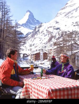 Pärchen in Resort Bar mit Matterhorn Mountain dahinter, Zermatt, Wallis, Schweiz Stockfoto