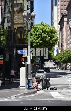 Los Angeles, CA/USA - 29. April 2020: Obdachlose und auf einer Straßenecke während der COVID-19 Quarantäne sitzend Stockfoto