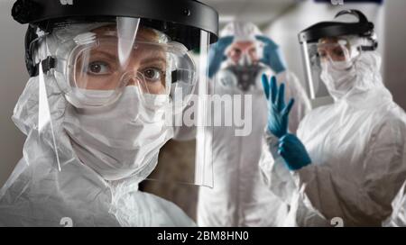 Team von Ärzten und Krankenschwestern und -Pflegern für Frauen und Männer, die persönliche Schutzkleidung im Krankenhausflur tragen. Stockfoto