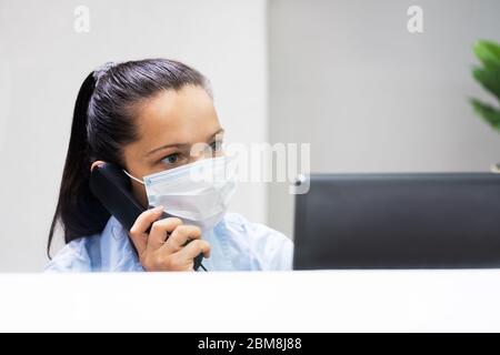 Frau An Der Rezeption An Der Rezeption Mit Gesichtsmaske Stockfoto