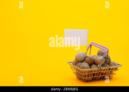 Walnüsse sind im Lebensmittelkorb, eine Fahne mit einem weißen Preisschild ist stecken Stockfoto