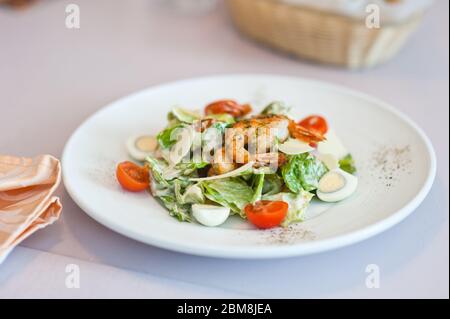 Shrimp Salat in einem weißen Teller auf einem Tisch im Café. Geringe Schärfentiefe. Stockfoto