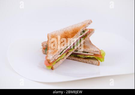 Schinken Sandwich auf einem Teller auf weißem Hintergrund Stockfoto