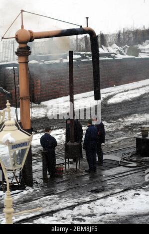 Das Personal hält sich warm durch den Feuerteufel im Hof von Bridgnorth. Stockfoto