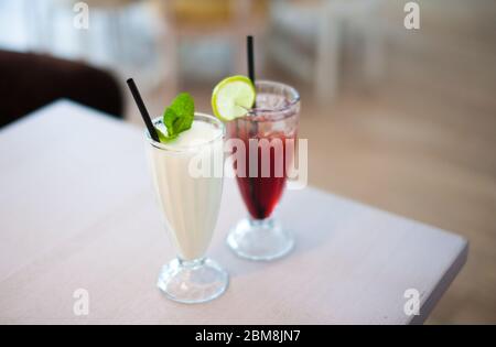 Zwei Gläser frische Limonade oder Cocktails mit Eis auf dem Tisch im Sommercafé. Geringe Schärfentiefe. Stockfoto