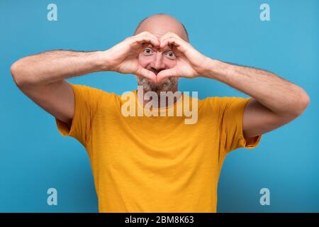 Schöner Mann, der mit seinen Händen ein Herz macht Stockfoto