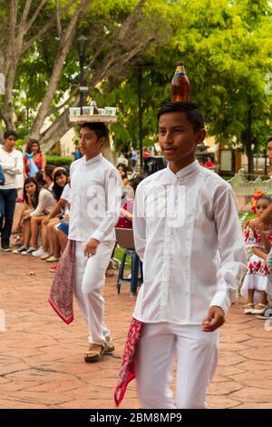 Traditioneller mexikanischer Folklore-Tanz auf dem öffentlichen Platz. Diese Tänzer balancieren Bier und Tequila auf ihren Köpfen, während sie zu Mariachi-Musik tanzen Stockfoto