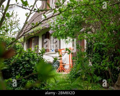 Blick vom Garten auf alte schöne Französisch Haus mit Bau mit orangefarbenen Böcken in der Nähe des Eingangs Stockfoto