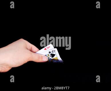 Eine Hand mit 2 Karten, die Blackjack spielen. Karten sind Herz-As und Pik-Dame Stockfoto
