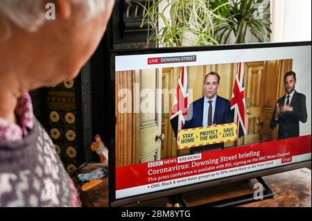 Stellvertretender Premierminister Dominic Raab gibt Coronavirus Downing Street Briefing, beobachtet von einem Zuschauer. "Bleib zu Hause, beschütze den NHS, rette Leben" -Banner. Stockfoto