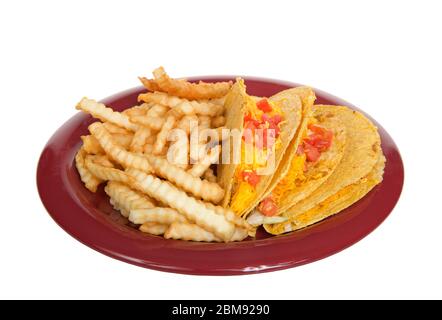 Drei knusprige Tacos auf einem roten Teller mit pommes Frites, isoliert auf Weiß. Populäres amerikanisiertes mexikanisches Essen. Stockfoto